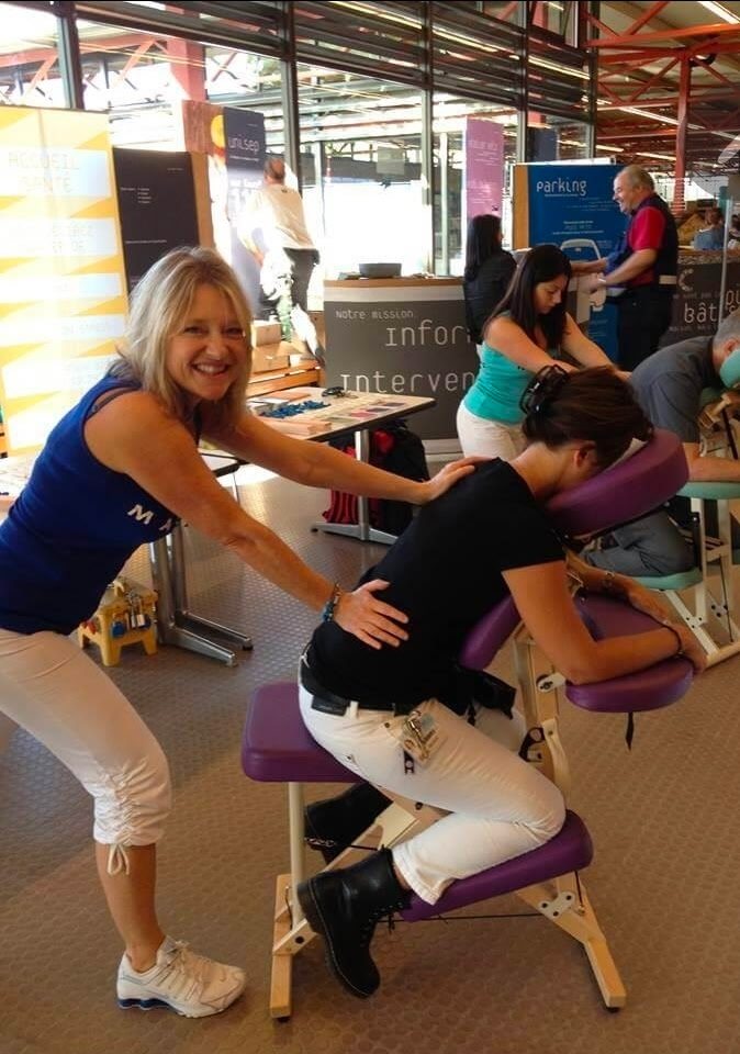 Wellness practitioner offering chair massage and healing therapy at the summit