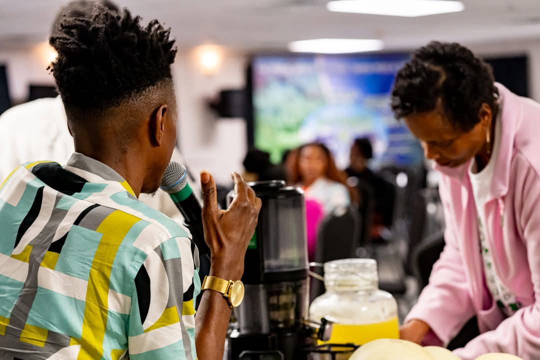 Marcus presenting at a juicing demonstration with attendee assisting